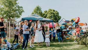 A lively outdoor gathering with families enjoying balloons and a sunny day.